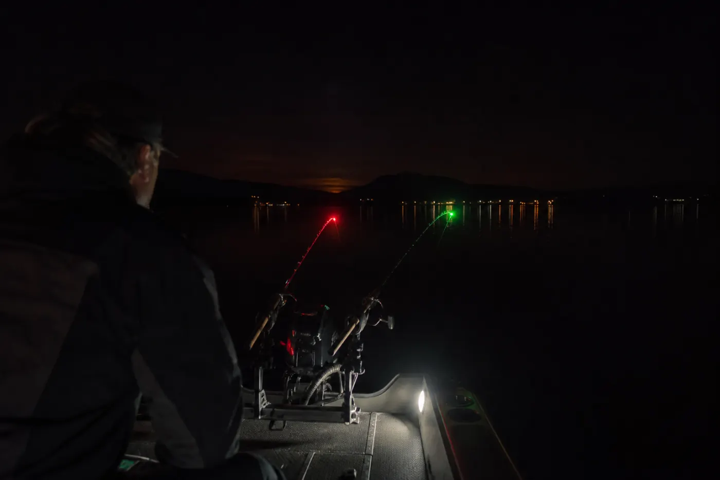 Nachtangeln und Trolling vom beleuchteten Angelboot auf einem See bei München